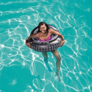 Frau im Wasser mit Bestway® Schwimmring Mud Master im Autoreifen-Design.