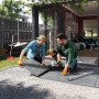 Verlegen von grauen Feinsteinzeug Terrassenplatten Streetline Graphit (60x60) im Garten.