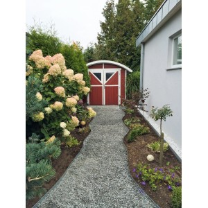 Gartenweg mit ACO Self® Kieswabe eco S befestigt, führt zu rotem Gartenhaus.