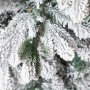 Detailaufnahme von einem künstlichen Weihnachtsbaum mit dichtem Kunstschnee auf grünen Zweigen. Perfekt für Weihnachtsdekoration.