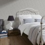 Graue A.S. Creation Vliestapete Vintage Style im Schlafzimmer mit Bett und Tür im Used-Look.