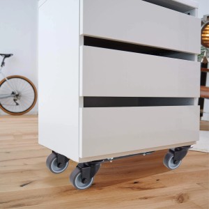 Wagner Transporthilfe Extender unter einem weißen Schrank mit Schubladen auf Holzboden.