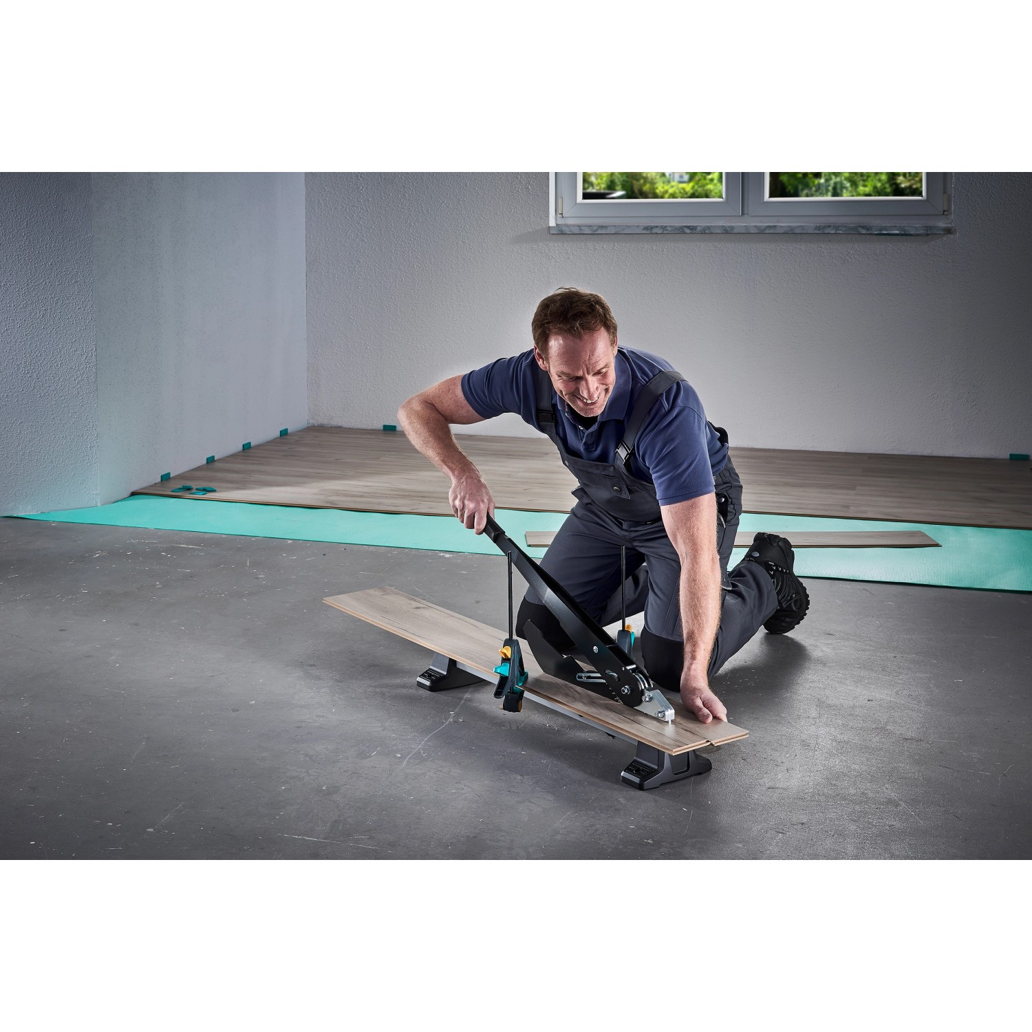 Mann schneidet Laminat mit dem wolfcraft Vinyl- und Laminatschneider VLC 1000.