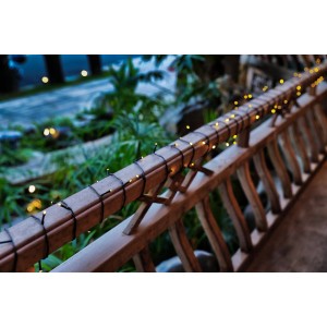 Schönenberger Solar Lichterkette mit 120 LEDs auf einem Holzbalkon, warmweißes Licht.