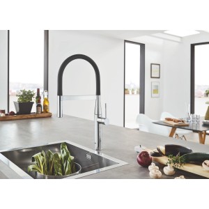 Grohe Essence Küchenarmatur in Chrom mit schwarzem, flexiblem Auslauf vor Küchenspüle.