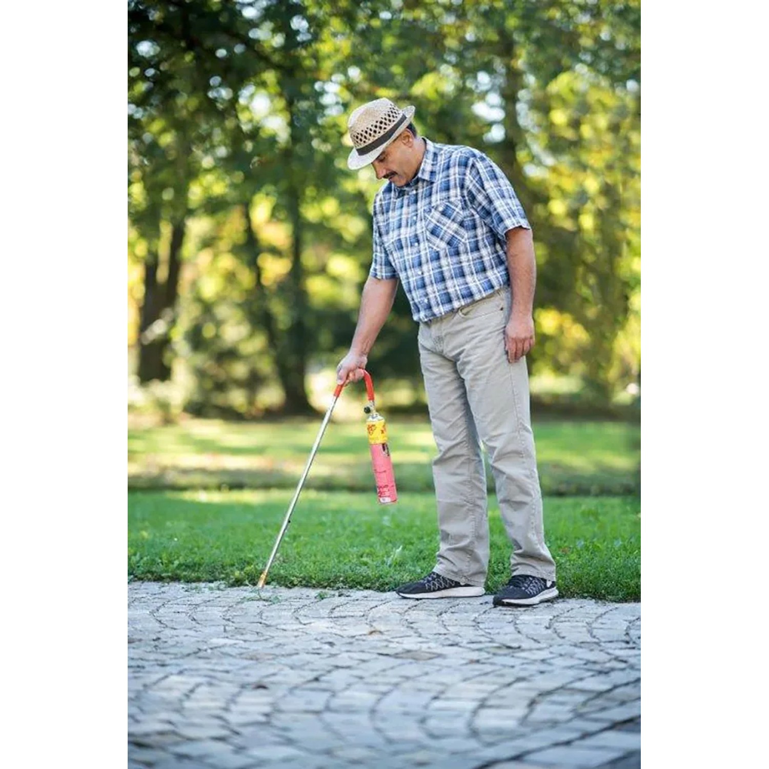 Rothenberger Abflammgerät Ökogärtner mit Piezo-Zündung im Einsatz gegen Unkraut auf Pflastersteinen.