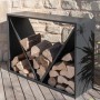 Schwarzes Westmann Kaminholzregal (114,5x35x80cm) mit Holzscheiten vor Steinwand.