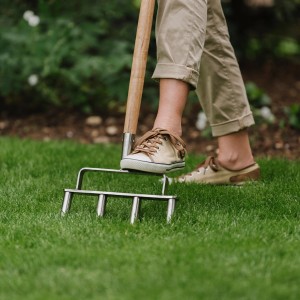 Kent & Stowe Rasenbelüfter im Einsatz: Person belüftet Rasen mit dem Gartenhandgerät.