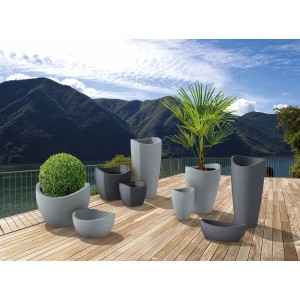 Scheurich Wave Globe Pflanzschalen in verschiedenen Größen und Farben auf einer Holzterrasse.