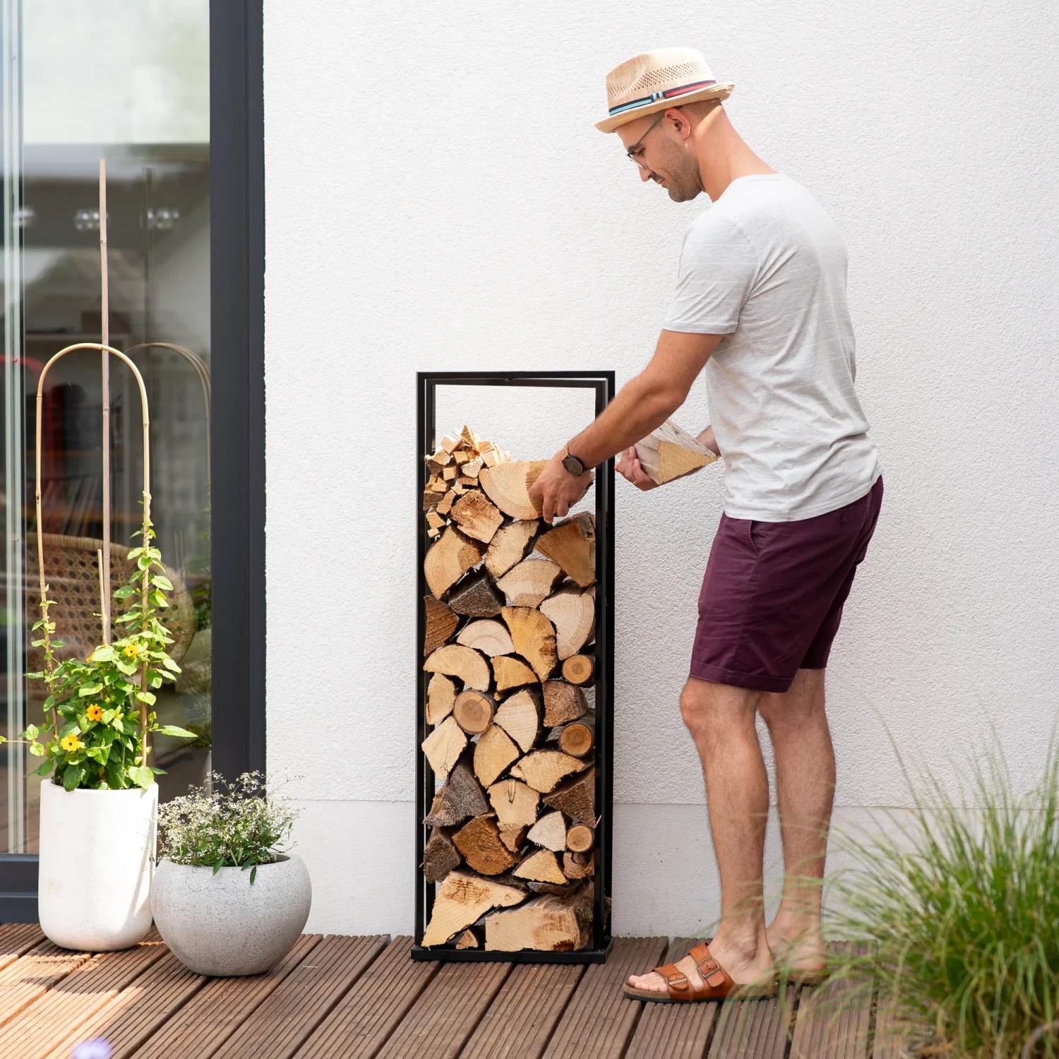 Schwarzes Westmann Kaminholzregal Xavier aus Stahl, befüllt mit Holzscheiten.