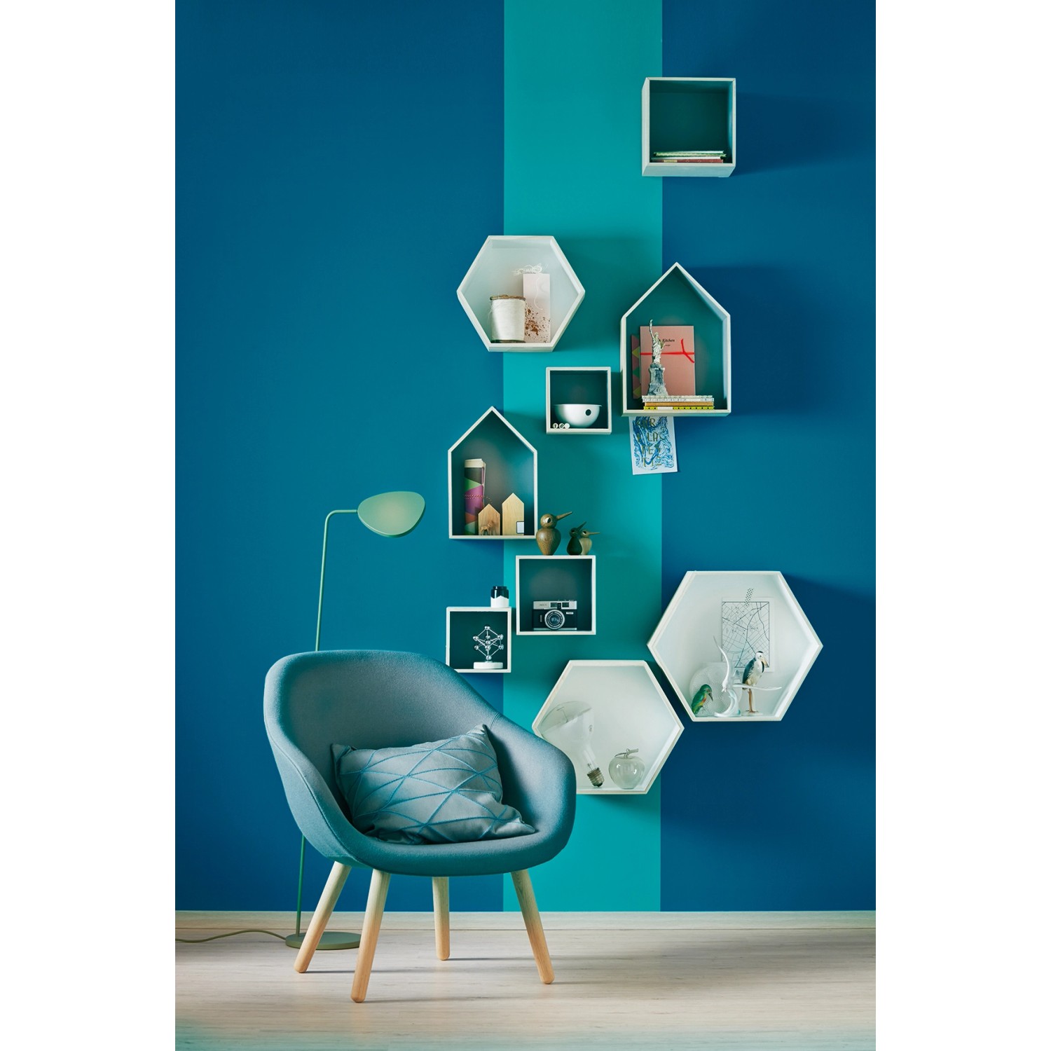 Wohnraum mit Schöner Wohnen Trendfarbe Lagune, matte Wandfarbe in blaugrün mit Stuhl und Regalen.