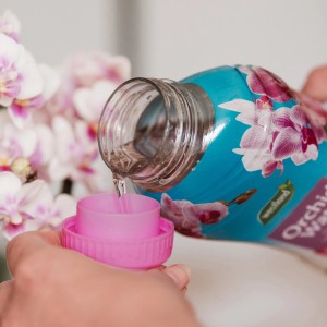 Westland Orchideen-Wasser wird in eine Dosierkappe gegossen. Orchideendünger für gesundes Wachstum.