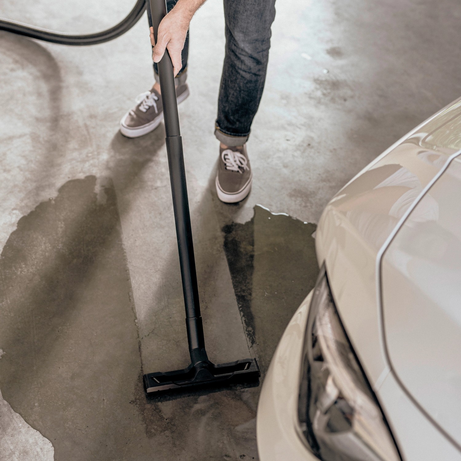 Kärcher WD 3 S V-17/4/20 Nass-/Trockensauger im Einsatz, reinigt Werkstattboden neben Auto.