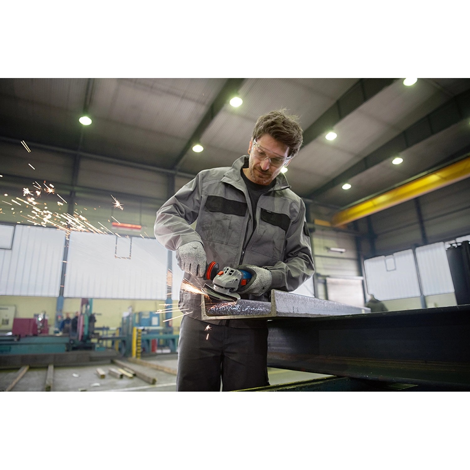 Mann schleift Metall mit Bosch Professional Winkelschleifer GWS 17-125 SB, Funken fliegen.