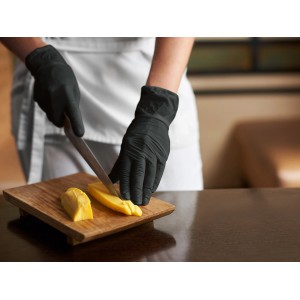 Schwarze, latexfreie Einmalhandschuhe Gr. M beim Schneiden von Käse.