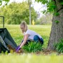 Schwarze Polar Cub Cart Schubkarre (127x71cm) im Einsatz bei Gartenarbeit.