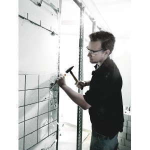 Handwerker stemmt Fliesen mit Wera Schraubendreher-Set und Hammer von der Wand.