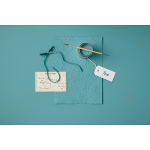 Rust-Oleum Kreidefarbe Petrol Matt mit Pinsel, Farbmuster und Postkarte auf petrolfarbenem Untergrund.