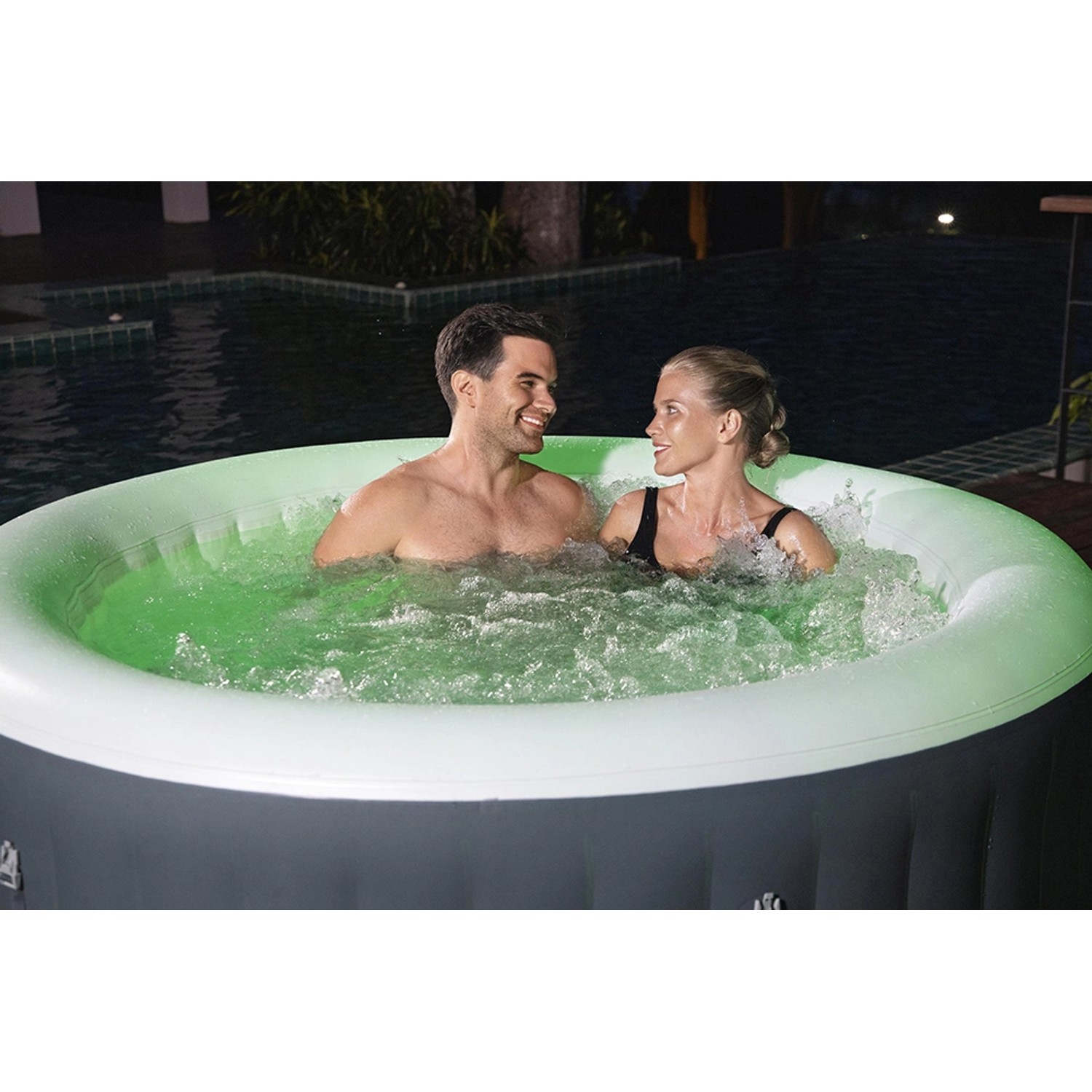 Bestway Lay-Z-Spa Bali AirJet aufblasbarer Whirlpool mit LED und Paar im Wasser.