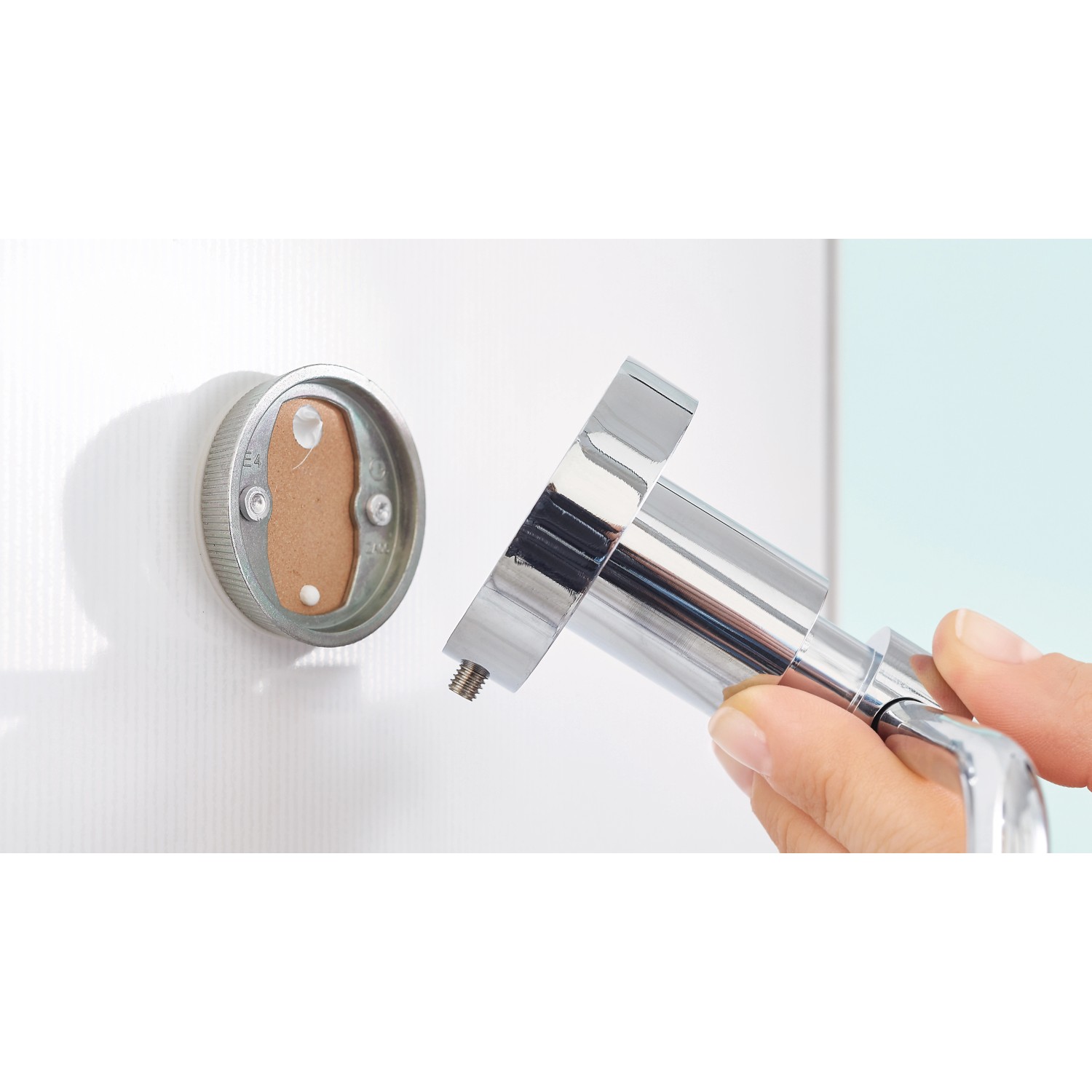 tesa® LOXX Toilettenrollenhalter Montage: Hochglanz verchromter Halter wird an der Wand befestigt.