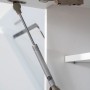 Detailaufnahme: Dämpfer und Scharnier an einem weißen Oberschrank der Respekta Premium Küchenzeile.