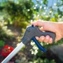 LUX Müllgreifer 87 cm in Aktion: Hand betätigt den Griff zum Aufsammeln von Gartenabfällen.