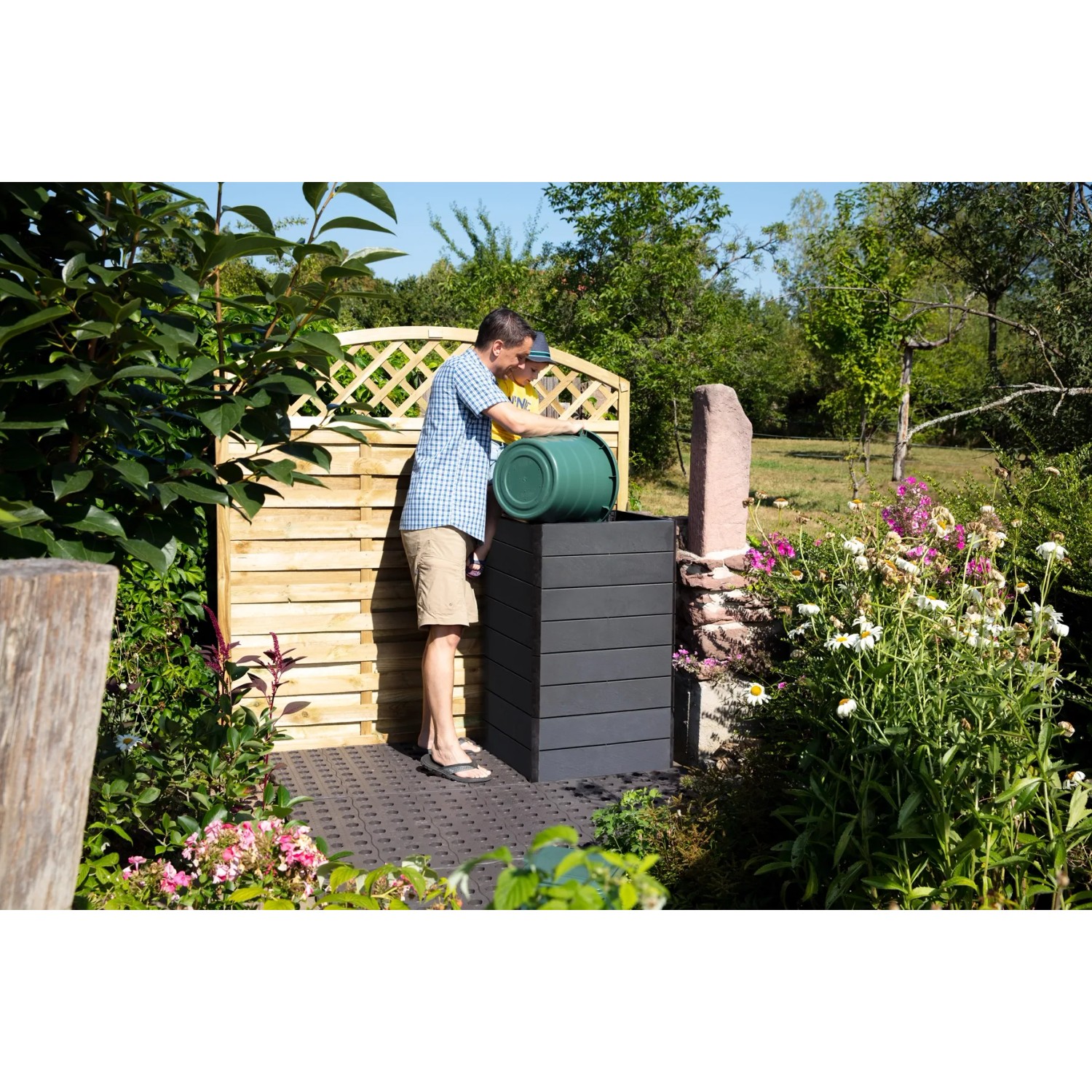 Garantia Hochbeet Ergo Quadro S Stone im Garten mit Person beim Befüllen.