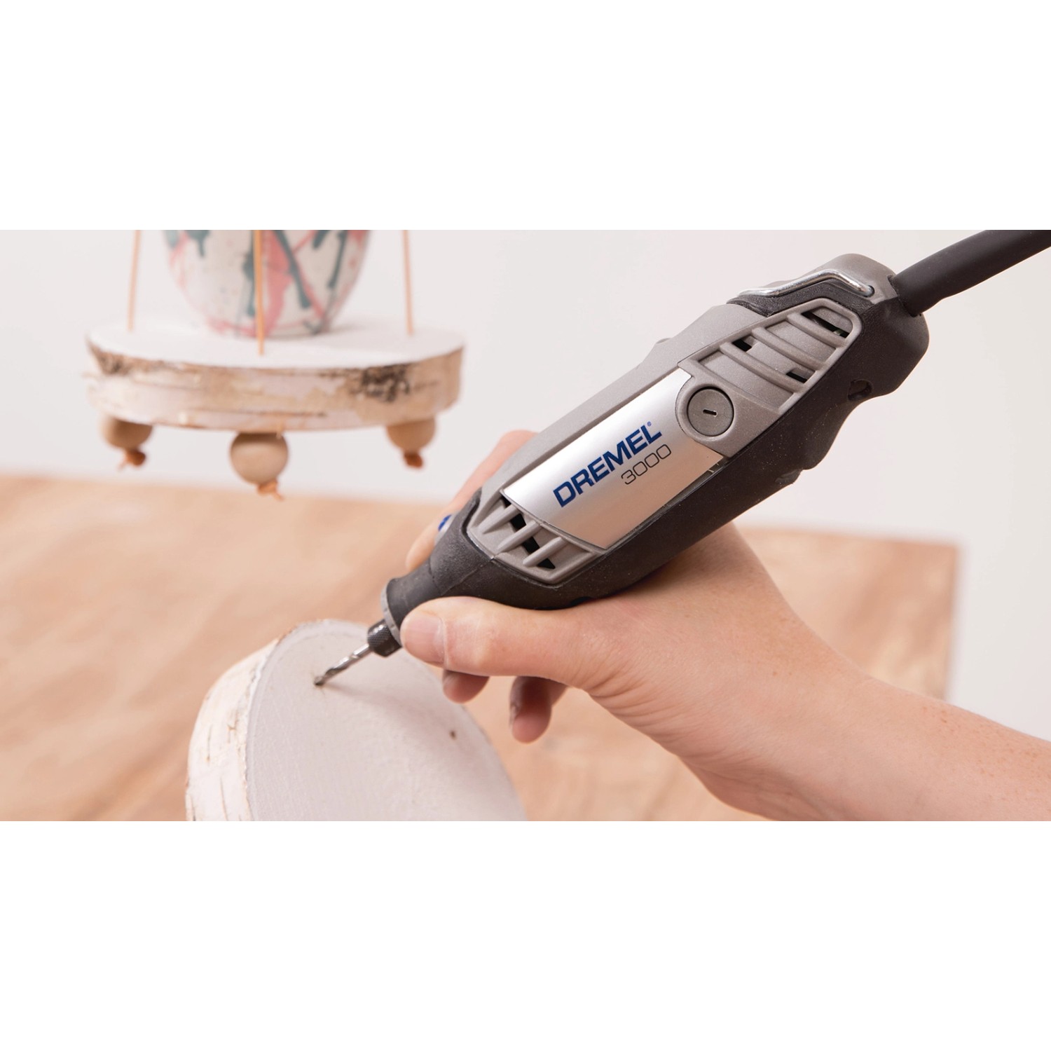 Dremel 681 Holzbearbeitungs-Set in Aktion: Miniaturwerkzeug bohrt Loch in Holz.