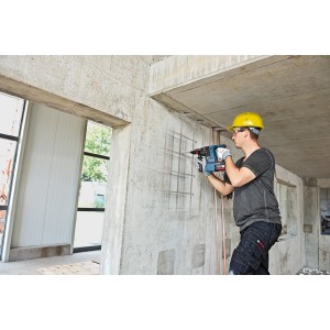 Handwerker bohrt mit Bosch Professional Akku-Bohrhammer GBH 18V-26F in Betonwand.