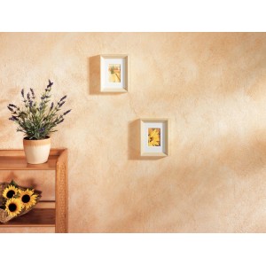Wandgestaltung mit Kreativ-Handschuh: Strukturierte, beige Wand mit Bildern und Pflanzen.