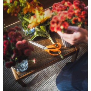Fiskars Universalschere Garten Classic 25 cm mit Blumen auf Tisch.