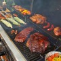 Pit Boss Memphis Ultimate Kombi-Grill mit Gas, Holzkohle und Smoker mit Grillgut.