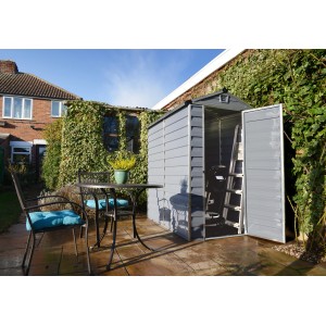 Graues Palram Canopia Gerätehaus Skylight 1.2 x 1.8 aus Kunststoff mit geöffneter Tür und Leiter im Inneren.