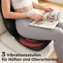 Schwarze HOMCOM Massagesitzauflage aus Leder/Stoff auf Sofa. Person entspannt lesend, rote Vibration für Hüften/Oberschenkel.