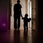 Osram LED-Nachtlicht Lunetta im Einsatz: Kind an der Hand einer erwachsenen Person in dunklem Flur, beleuchtet durch Nachtlicht.