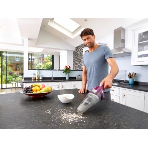 Black+Decker Akku-Handstaubsauger NVC115W im Einsatz auf Küchentisch zum Aufsaugen von Krümeln.