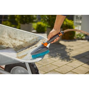 Gardena Cleansystem Handbürste Hard M mit Schlauchanschluss beim Reinigen einer Schubkarre.