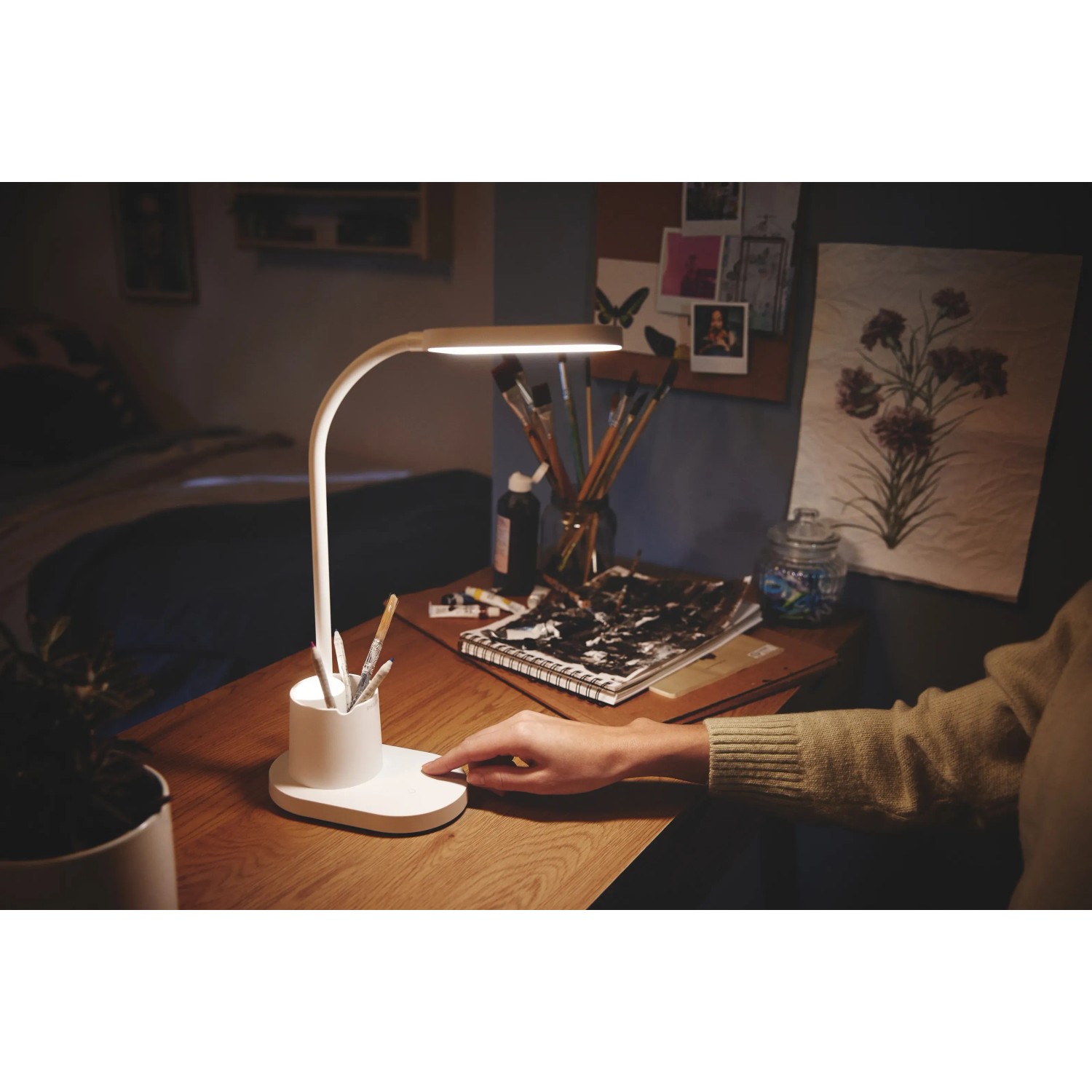 Weiße Philips LED-Tischleuchte Bucket mit Stifthalter auf einem Schreibtisch.