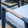 Detail der Elati Gartenlounge: Dunkle Aluminium-Armlehne mit Teak-Look-Akzent und hellgrauem Kissen. Modernes Design.