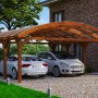 Skan Holz Doppelcarport Franken Nussbaum mit zwei geparkten Autos unter dem Carport.