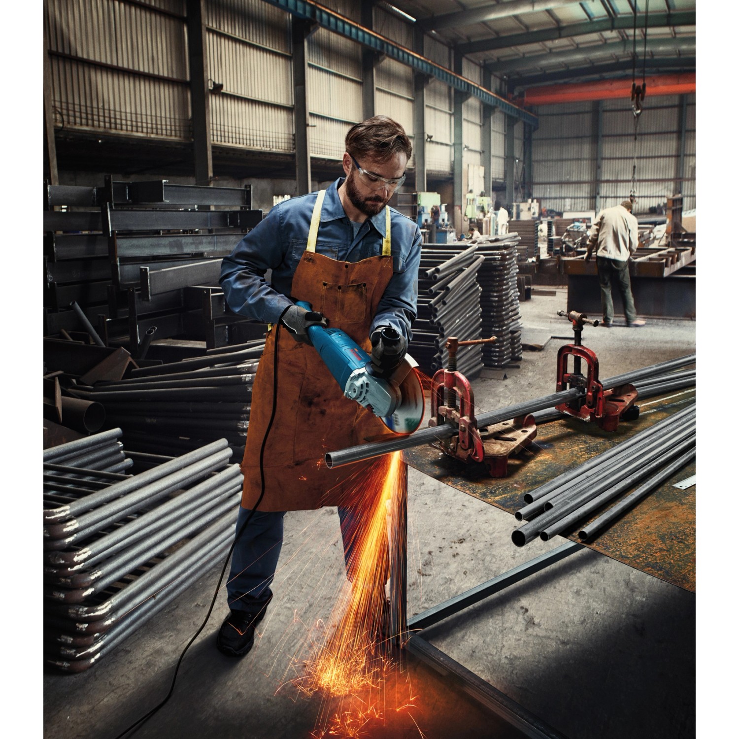 Mann schneidet Metall mit dem Bosch Professional Winkelschleifer GWS 22-230 P. Funken fliegen.