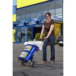 Frau transportiert Farbeimer und Rollen mit der klappbaren wolfcraft Sackkarre TS 850 (100 kg) vor dem OBI Markt.