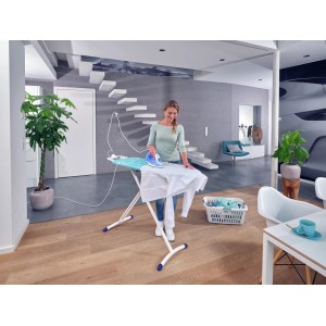 Frau bügelt Wäsche auf dem Leifheit AirBoard Premium M Plus Bügeltisch mit Steckdose.