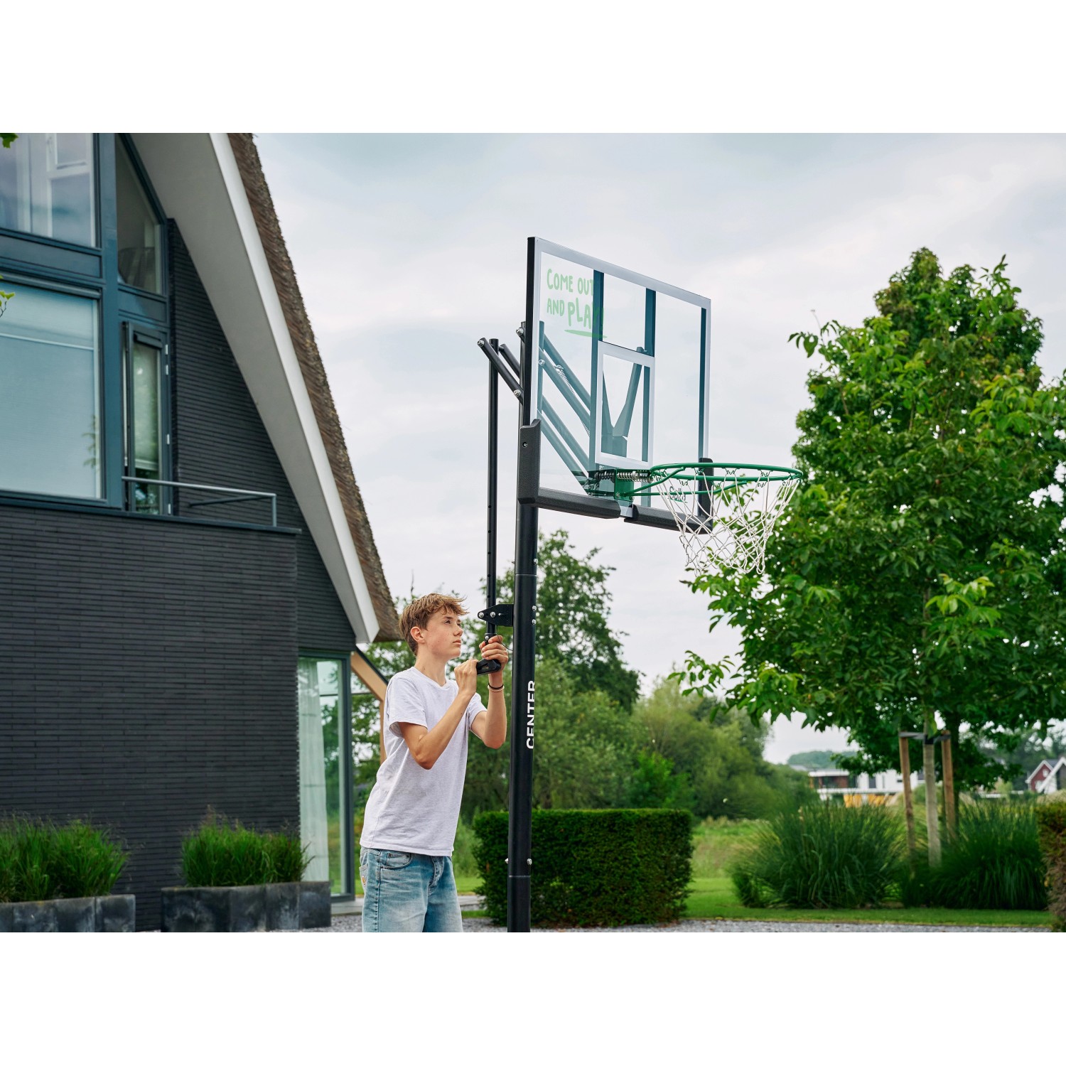 Salta Basketballständer Center mit Jugendlichem beim Verstellen der Höhe.