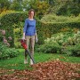 Frau benutzt Einhell Akku-Laubbläser GE-UB 18/250 Li E im Garten, um Laub zu entfernen.