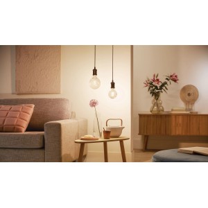 Philips Smart LED Filament G95, 7W, E27 in Wohnraum-Szene mit warmem Licht.