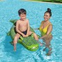 Kind auf Bestway Schwimmtier Krokodil im Pool, begleitet von Erwachsener. Wasserspaß im Sommer.