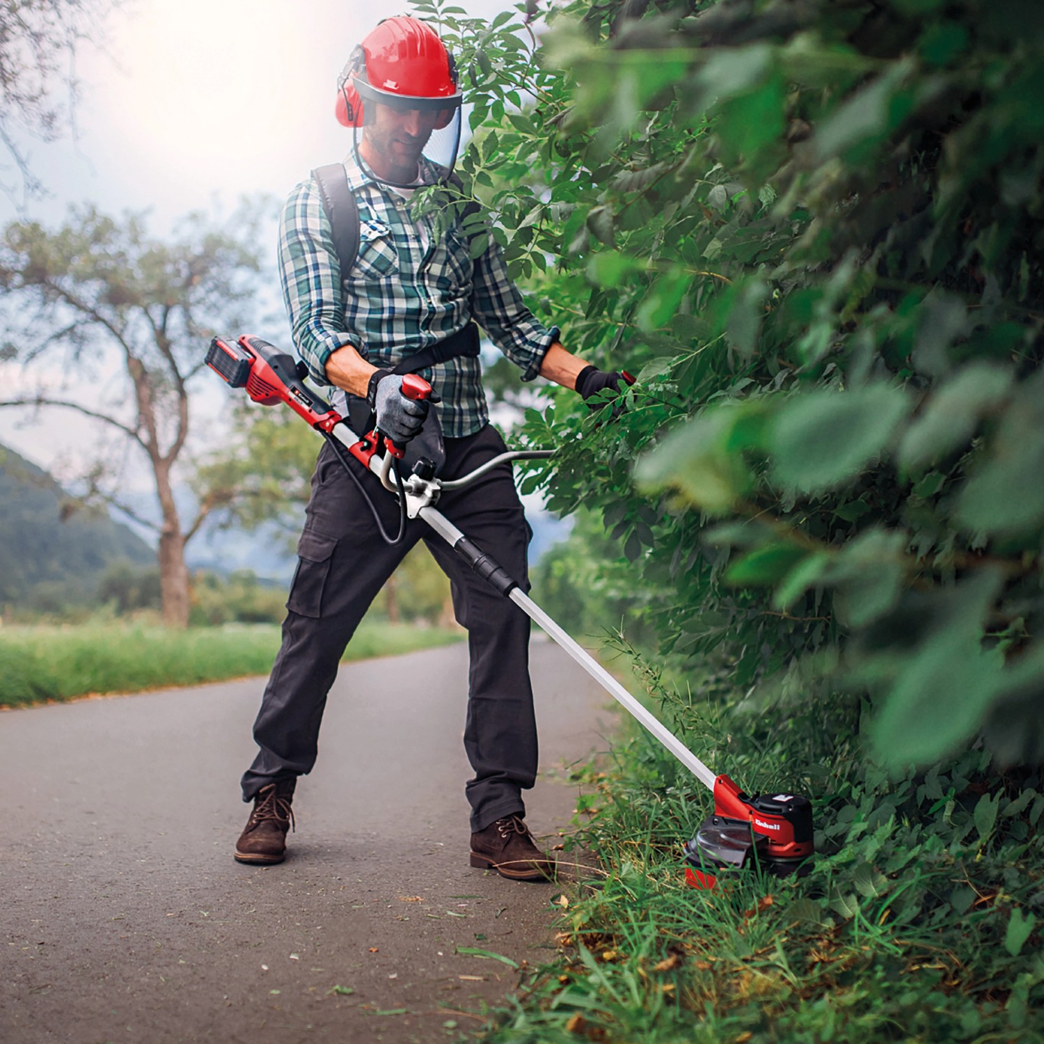 Einhell Akku-Sense Agillo Power X-Change im Einsatz beim Trimmen von Gras und Büschen.