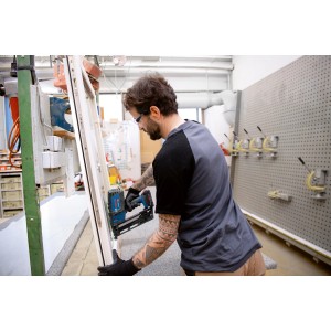 Handwerker befestigt Leiste mit Bosch Professional Akku-Holznagler GNH 18V-64.