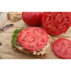 Rosafarbene Blu Tomate Rose Crush auf Brot, angeschnitten und ganz auf Holzbrett.